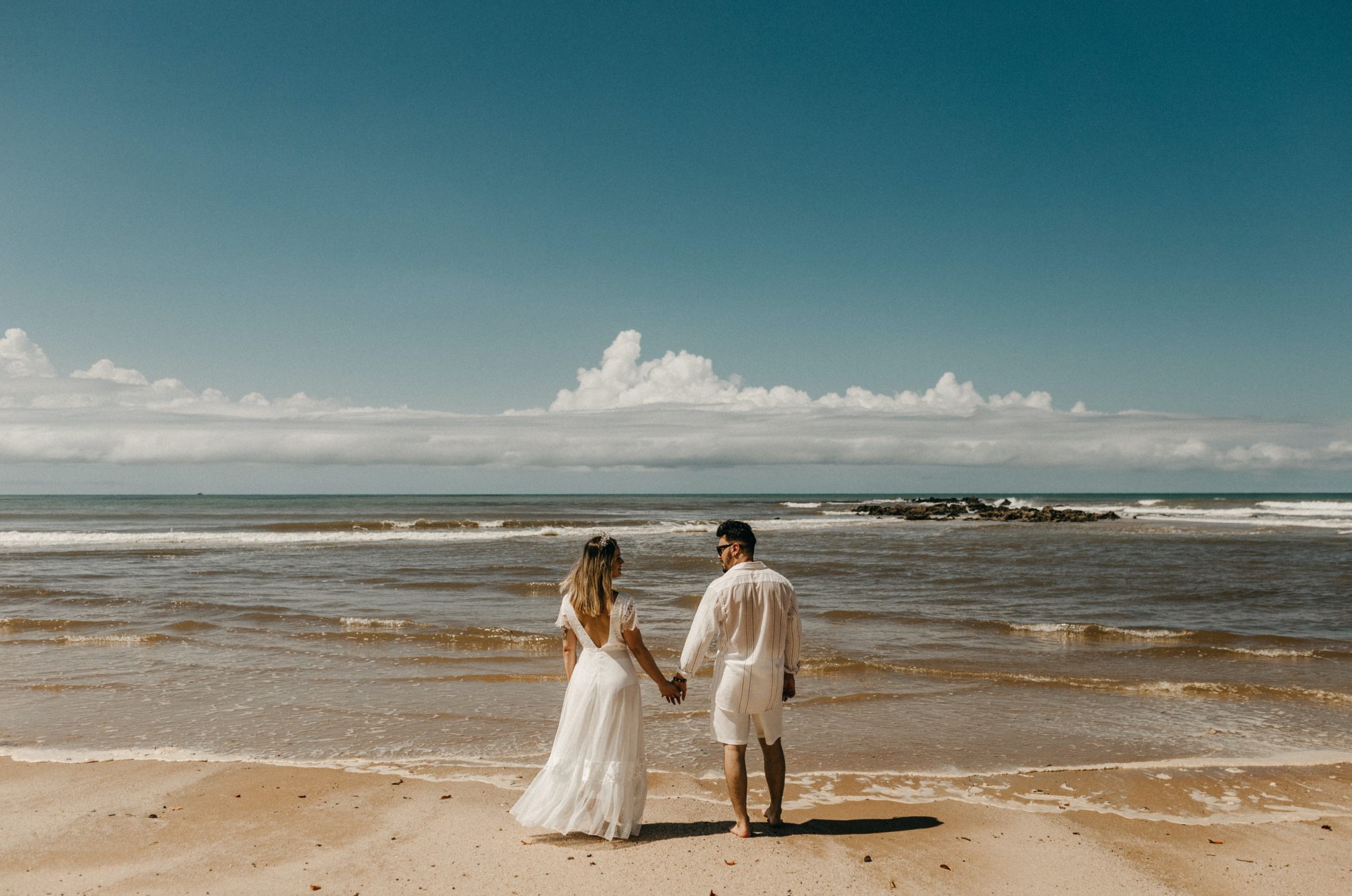 woman and man standing in front of shoreline